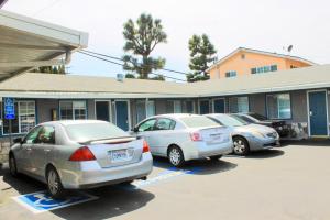 three cars parked in a parking lot in front of a building at Arlington Motel in Long Beach +16 photos