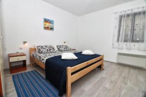 een slaapkamer met een groot bed en een blauwe deken bij Apartment Edi in Pula