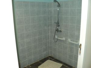 La salle de bains est pourvue d'une douche et de carrelage. dans l'établissement Le Gîte du Clos Boisé, à Théziers