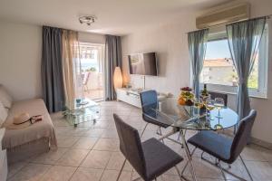 a living room with a glass table and chairs at Apartment Luna in Malinska