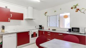 アヌシーにあるAppartement Annecyの赤いキャビネットと赤い椅子付きのキッチン