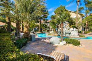 a patio with palm trees and a swimming pool at Strip View luxury Condo in Las Vegas