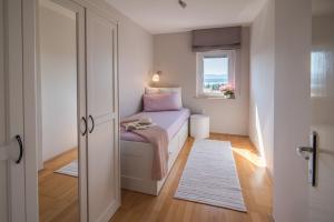a small bedroom with a bed and a window at Apartment Luna in Malinska