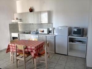 a kitchen with a table and a refrigerator and a microwave at Kampor Apartments in Kampor