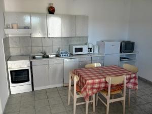 a kitchen with a table with chairs and a microwave at Kampor Apartments in Kampor +47 photos