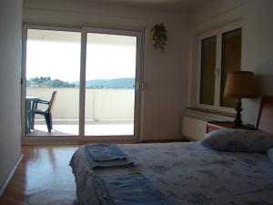 a bedroom with a bed and a large sliding glass door at Kampor Apartments in Kampor