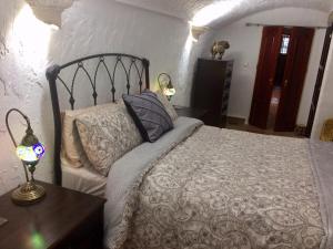 A bed or beds in a room at Cueva Romana Cave House, Clothing Optional, Adult Only