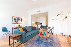 ein Wohnzimmer mit einem blauen Sofa und einem Tisch in der Unterkunft Bacalhoeiros 99 - Beautiful and bright Apartment @ Baixa, Chiado in Lissabon