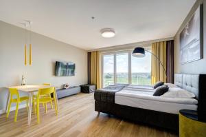 a bedroom with a bed and a table and chairs at Zacne Apartamenty in Jastarnia