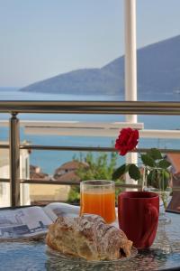 a table with a glass of orange juice and a pastry at JK apartmani in Herceg-Novi
