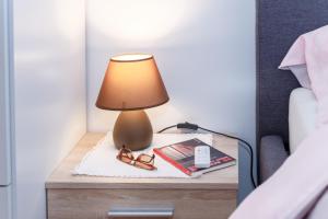 une lampe sur une table à côté d'un lit dans l'établissement Alp Apartma, à Radovljica