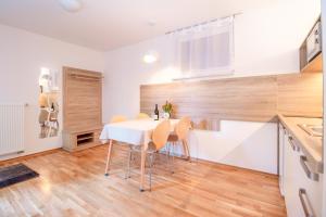 a kitchen and dining room with a white table and chairs at Alp Apartma in Radovljica