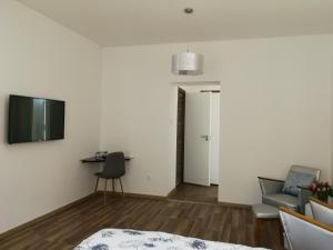 a living room with a bed and a tv on a wall at Class Apartment in Szeged