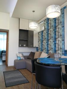 uma sala de estar com um sofá e uma mesa em Class Apartment em Szeged