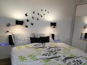 a bedroom with a bed with black birds on the wall at Class Apartment in Szeged