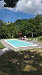 una piscina con dos personas sentadas en ella en Mazzamurello en Caldarola