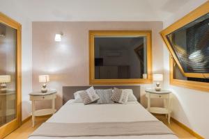 a bedroom with a bed with two night stands and a mirror at Country Domos Tramentu in Ozieri +32 photos