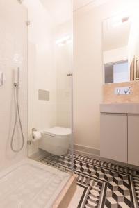 a bathroom with a toilet and a glass shower at Bacalhoeiros 99 - Beautiful and bright Apartment @ Baixa, Chiado in Lisbon