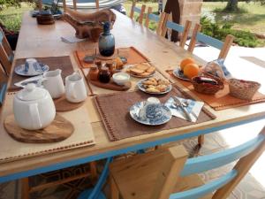a wooden table with breakfast foods on it at B&B La Gufa in Cisternino