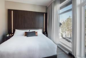 a bedroom with a bed and a large window at Entourage sur-le-Lac in Lac-Beauport +37 photos