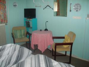 ein Schlafzimmer mit einem Tisch und Stühlen sowie einem TV in der Unterkunft Glyngøre Bed & Breakfast in Glyngøre