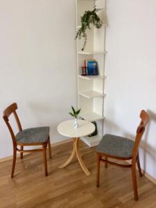 een kamer met 2 stoelen, een tafel en een plank bij Julius Vendégház in Sopron