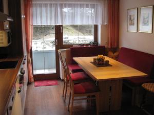 a kitchen with a wooden table and chairs and a table and a window at Apart Kathrin in Kappl
