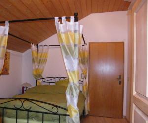 Schlafzimmer mit einem Bett mit gelben und weißen Vorhängen in der Unterkunft Ferienhaus Landau in Landau an der Isar