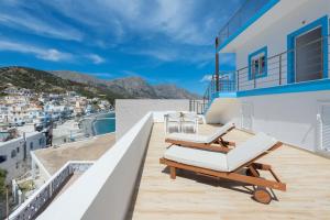 a balcony with chairs and a view of a city at villa Diafani, Εirini in Diafani
