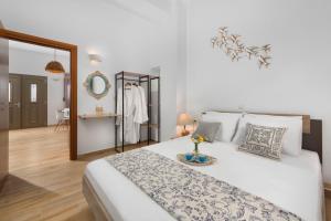 a white bedroom with a large white bed and a mirror at villa Diafani, Εirini in Diafani