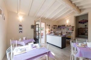 un restaurante con mesas y sillas moradas y una barra en Il Lavandeto - farmhouse in the city, en Siena