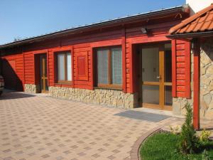 a red house with a brick driveway in front of it at Privat u Starona in Liptovský Ján