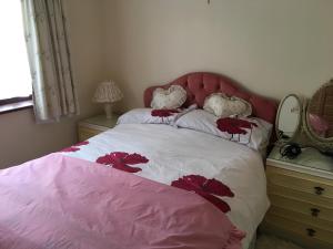 a bedroom with a pink bed with flowers on it at Dream On in St Margarets at Cliff