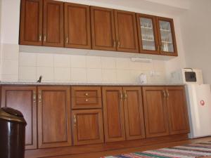 Una cocina con gabinetes de madera y un refrigerador blanco. en Privat u Starona, en Liptovský Ján