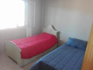 1 dormitorio con 2 camas y ventana en Casa Las Lomas El Nihuil en El Nihuil