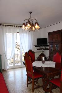 comedor con mesa, sillas y lámpara de araña en Casa di gianni, en Primaluna