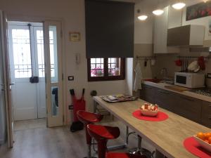 a kitchen with a counter with red chairs and a table at Roman Theater in Verona