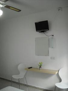 a television is sitting on a stand in a room at Hostal Flor Blanco in Torremolinos