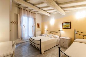 a bedroom with two beds and a window at Il Lavandeto - farmhouse in the city in Siena