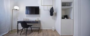 a white room with a desk and a chair at Suite Vogue Espresso in Voghera