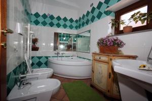 y baño con bañera, aseo y lavamanos. en B&B Su Biancu - Sardinian Experience, en Urzulei