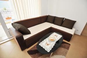 - un canapé brun dans le salon avec une table dans l'établissement Apartman ANNA Đenovići, à Herceg-Novi