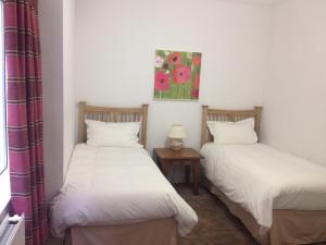 two twin beds in a room with a table at 2 Crescent Gardens Guest House in Bath