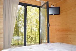 a bedroom with a bed and a large window at Bamboo Guest House in Águeda