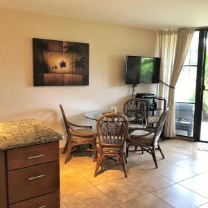 基黑的住宿－Aloha WAI，客厅配有桌椅和电视。