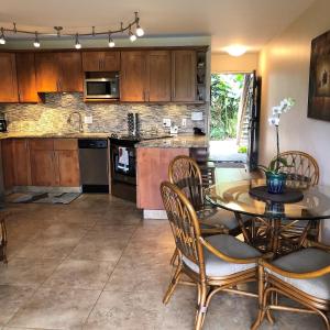 a kitchen with a table and chairs and a kitchen with a counter at Aloha WAI in Kihei