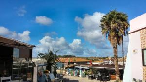 a palm tree sitting next to a street with a building at Alvor Ria Apartment in Alvor