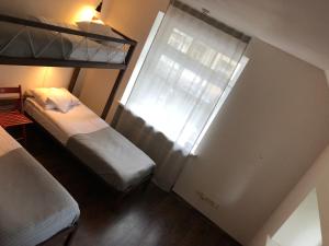een kleine slaapkamer met twee bedden en een raam bij Rock'n'hostel in Vilnius
