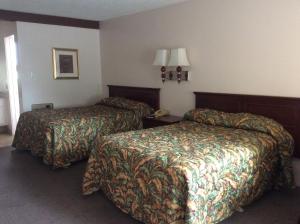 מיטה או מיטות בחדר ב-Torch Lite Lodge