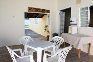 a dining room with a table and four chairs at Chácara Bom Jesus in Aparecida